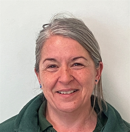 Photograph of a woman with silver hair wearing a dark green polo shirt and fleece. She is smiling nicely. Photograph of a woman with silver hair wearing a dark green polo shirt and fleece. She is smiling nicely.